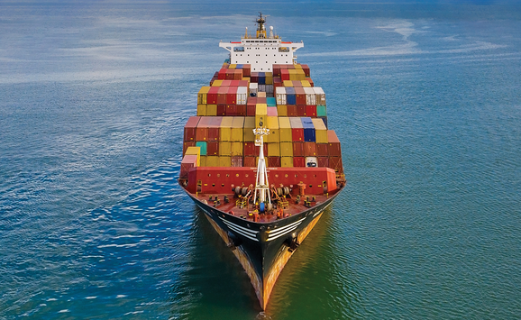 A freight full of shipping containers in the ocean on a sunny day