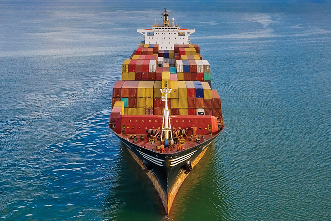 A freight full of shipping containers in the ocean on a sunny day