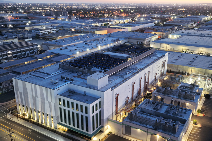 A large data center at dusk with a surrounding community in the background