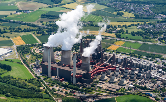 Aerial view of brown coal power plant close to Aachen, Germany. White smoke comes from three huge cooling towers.