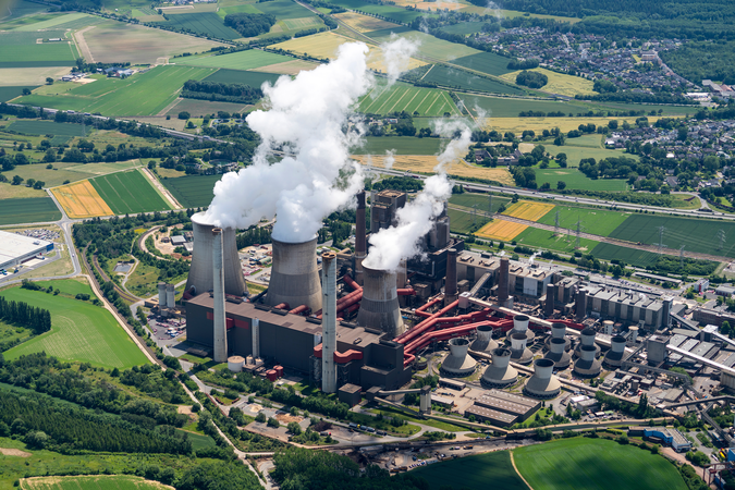 Aerial view of brown coal power plant close to Aachen, Germany. White smoke comes from three huge cooling towers.