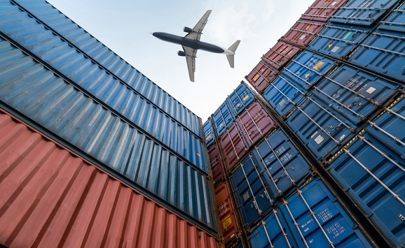 A view from below as a freight plane flies overhead stacked shipping containers