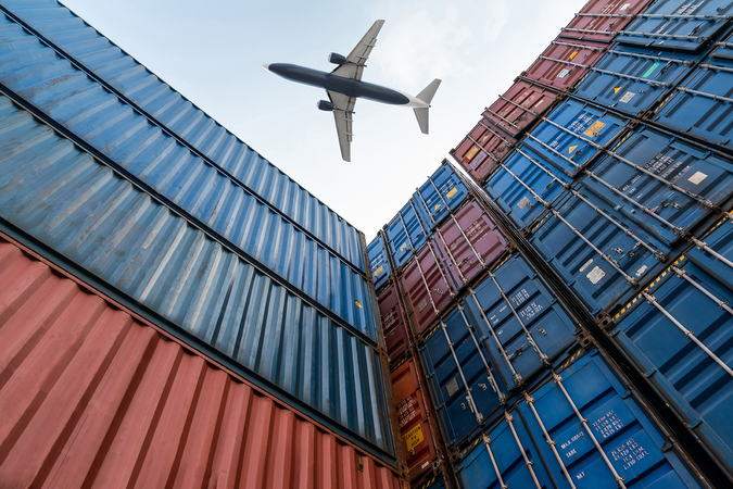 A view from below as a freight plane flies overhead stacked shipping containers