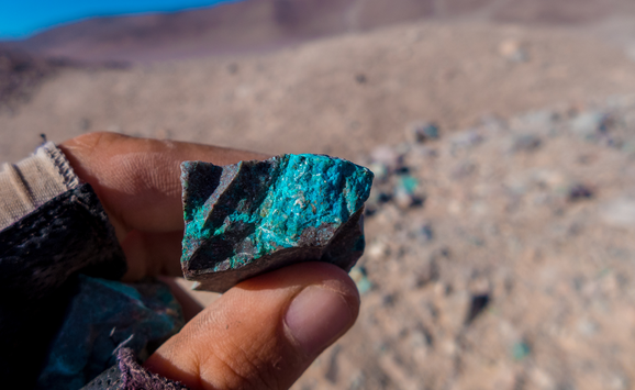 Someone holding a natural copper ore containing rock found in the Atacama desert in Chile.
