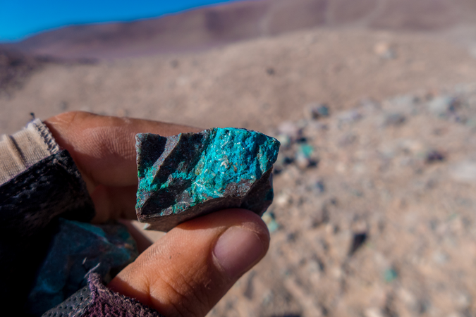 Someone holding a natural copper ore containing rock found in the Atacama desert in Chile.