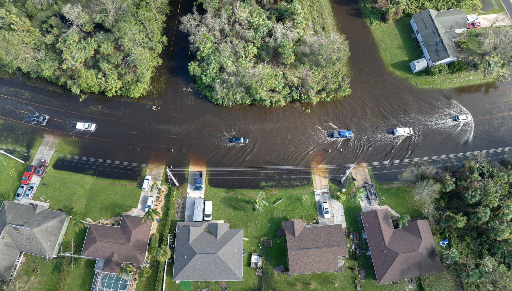 Aerial image of cars driving on flooded road in a Florida suburb