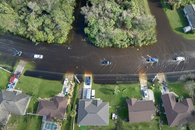 Aerial image of cars driving on flooded road in a Florida suburb