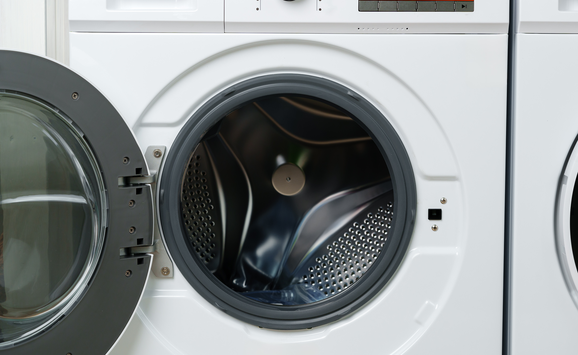 A closeup image of a white front-loading clothes washing machine.