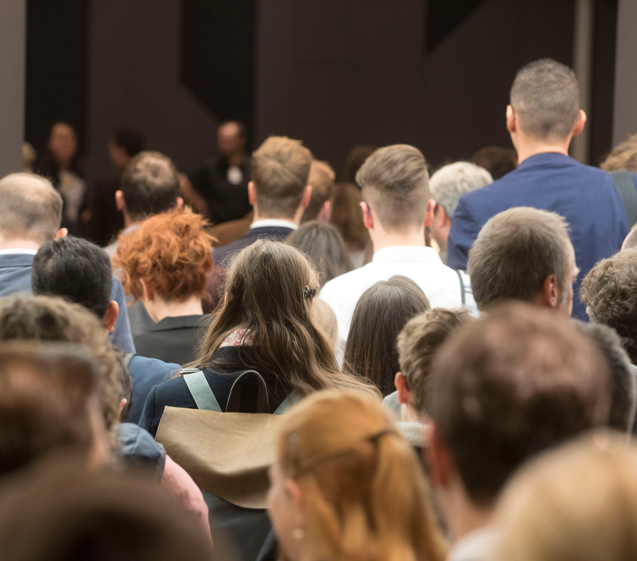 Crowd of employees entering a building in business attire.