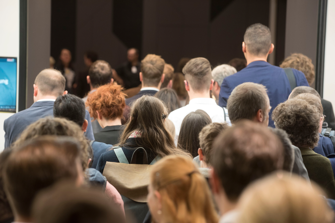 Crowd of employees entering a building in business attire.
