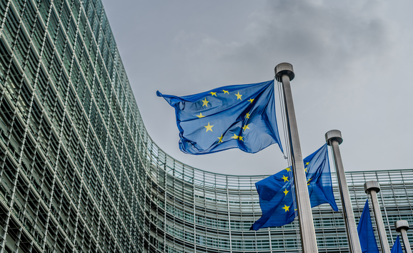 European Union flags flying in front of the Berlaymont building, which is the headquarters of the European commission located in Brussels.